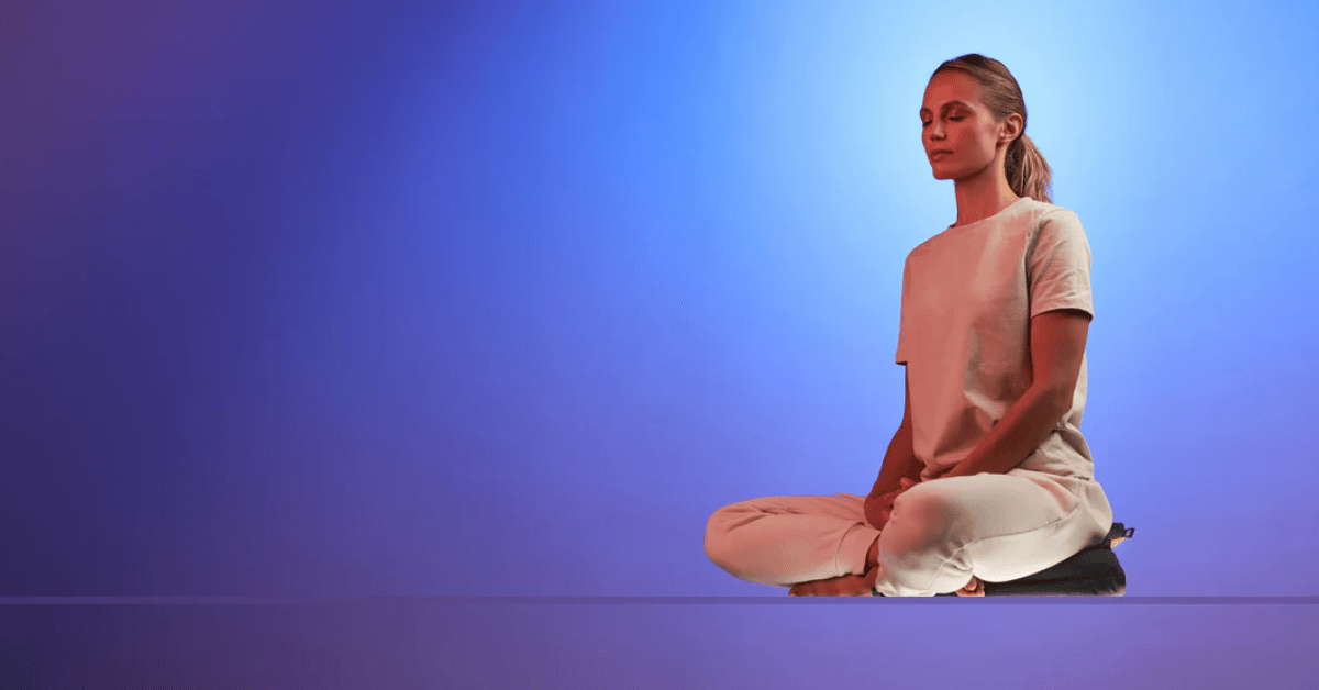 Woman practicing mindfulness meditation on a SUMA cushion